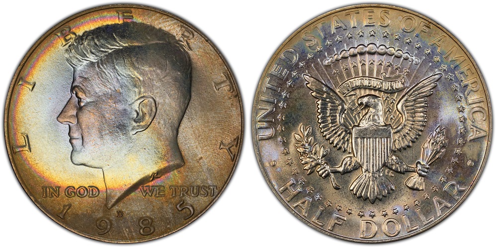 Side-by-side comparison of a typical MS64 1985 Kennedy Half Dollar and a gem MS67 example showing differences in strike and luster
